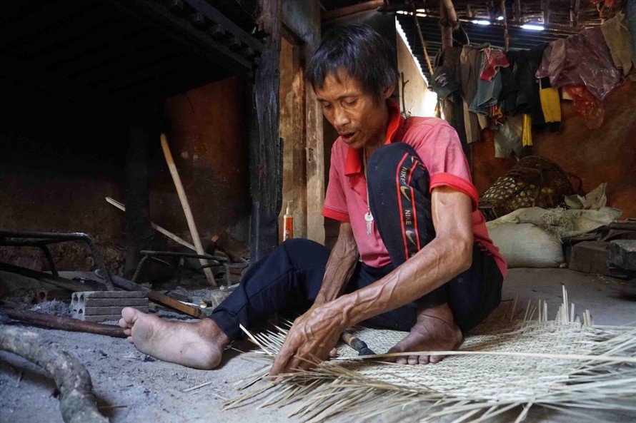 Lúc mắc bệnh, “người rừng” vẫn đan thúng, nia bằng sợi rừng bán cho người trong làng để mưu sinh Ảnh: Nguyễn Ngọc 