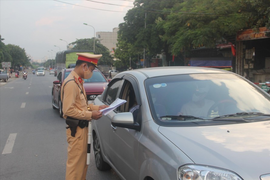 Lực lượng chức năng kiểm tra giấy đi đường của người dân ra vào vùng đỏ ảnh: Long Vân 