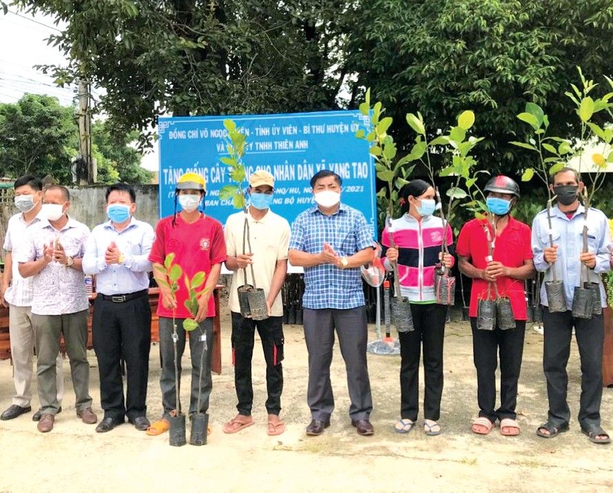 Bí thư Huyện ủy Võ Ngọc Tuyên (giữa) tặng cây giống cho người dân 