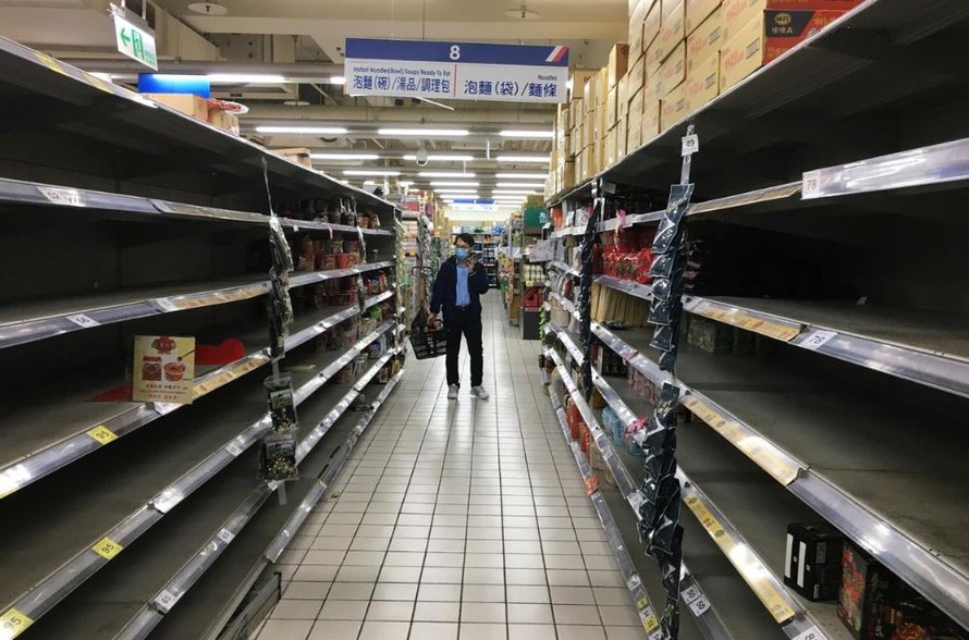 Một khách hàng bên các kệ trống vốn bày bán mì ăn liền tại siêu thị Carrefour, sau khi dịch COVID-19 bùng phát, tại Đài Bắc, Đài Loan ngày 21/3 Ảnh: REUTERS 