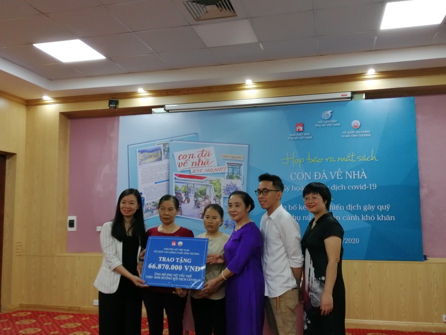 Đại diện NXB và tác giả Tăng Quang (áo trắng) tặng quà trích từ tiền bán sách cho những phụ nữ yếu thế bị ảnh hưởng bởi dịch COVID-19 