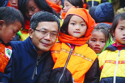 Nhà báo Trần Đăng Tuấn với trẻ em vùng cao mà ông và cộng sự mang cho cái ăn, cái mặc Ảnh: Phạm Ngọc Tiến