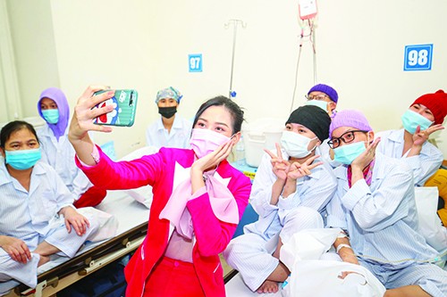 Hoa hậu Đỗ Thị Hà chụp ảnh cùng các bệnh nhân khi thăm tặng quà tại Viện Huyết học và Truyền máu T.Ư Ảnh: Như Ý