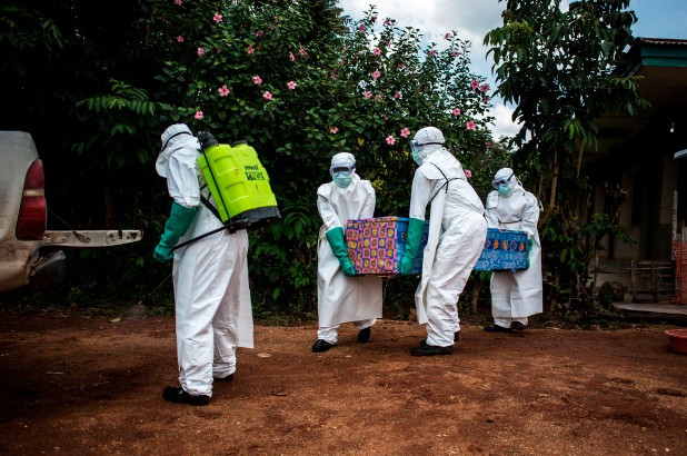Các nhân viên y tế đưa các thi thể người chết vì dịch cúm Ebola đi chôn cất.