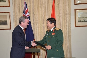 Bộ trưởng Quốc phòng Australia và Việt Nam trao đổi văn kiện vừa ký kết. 