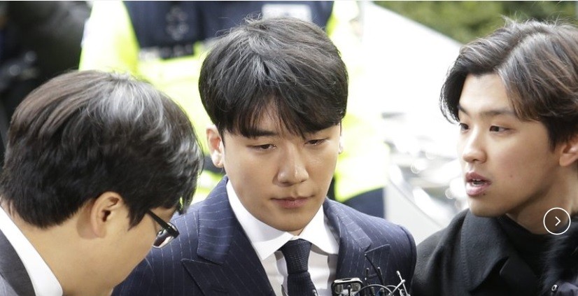 Sao Hàn Seungri ( giữa) xuất hiện tại đồn cảnh sát ở Seoul ngày 13/4 trước hơn 100 phóng viên.