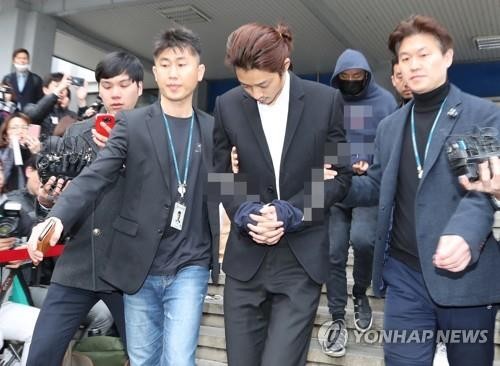 Ca sỹ Joon-young bị còng tay và chuyển từ nơi giam giữ ở đồn cảnh sát sang cơ quan công tố.