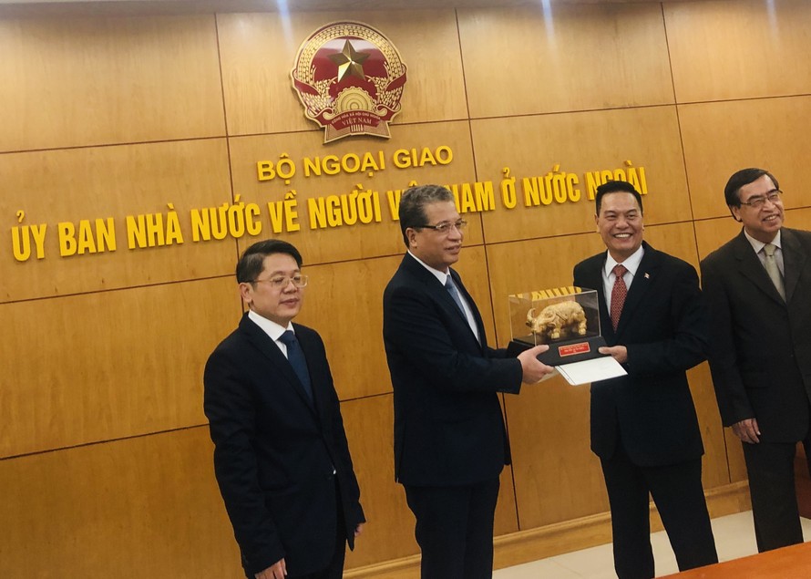 Thứ trưởng Đặng Minh Khôi ( thứ hai từ trái sang) trao tặng “ linh vật Trâu vàng” và thư chúc Tết của Thủ tướng Nguyễn Xuân Phúc cho ông Nguyễn Hoài Bắc, kiều bào Canada. 