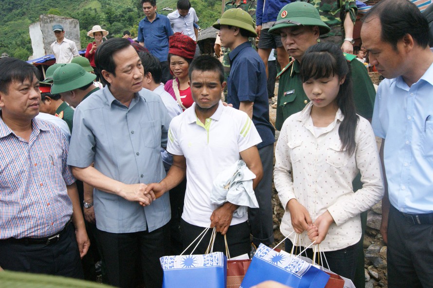 Bộ trưởng Đào Ngọc Dung trao quà và động viên anh Lò Văn Cu, cháu Quàng Thị Xuân ở xã Nậm Păm mất người thân trong trận lũ dữ
