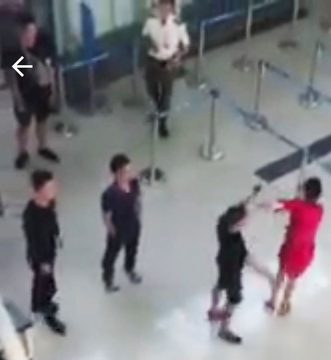 Nhân viên hàng không Lê Thệ Gi. (áo đỏ) bị nhóm hành khách đánh hội đồng vì từ chối chụp ảnh cùng. (Ảnh cắt từ clip).