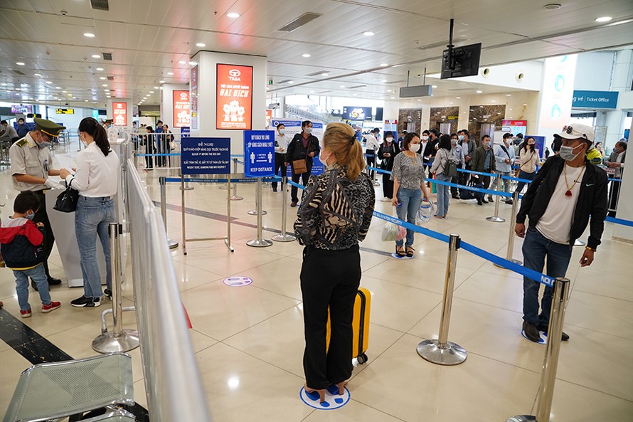 Hành khách làm thủ tục tại sân bay Nội Bài được yêu cầu xếp hàng cách nhau tối thiểu 2m để phóng chống dịch.