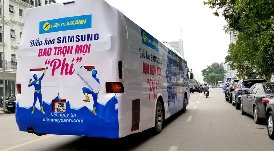 Xe khách dán kín quảng cáo, vi phạm quy định về an toàn giao thông, nhưng vẫn vô tư lưu thông trên khắp các tuyến phố của Hà Nội. Ảnh: Phạm Thanh.