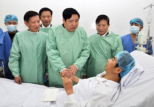 Bộ trưởng Bộ Quốc phòng Phùng Quang Thanh thăm và tặng quà anh Huyên sau ca ghép tạng. Ảnh: Bệnh viện cung cấp. 