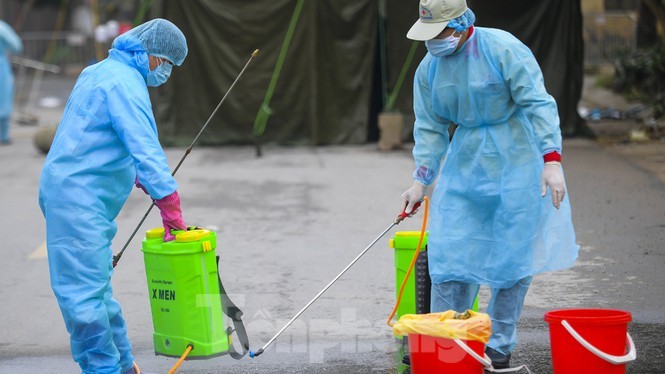 Nhân viên y tế phun thuốc khử khuẩn môi trường tại ổ dịch Hạ Lôi, Mê Linh, Hà Nội. Ảnh: Mạnh Thắng