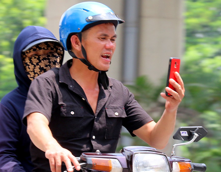 Bất chấp nguy hiểm, nhiều người 'dán mặt' vào điện thoại khi đi ô tô, xe máy