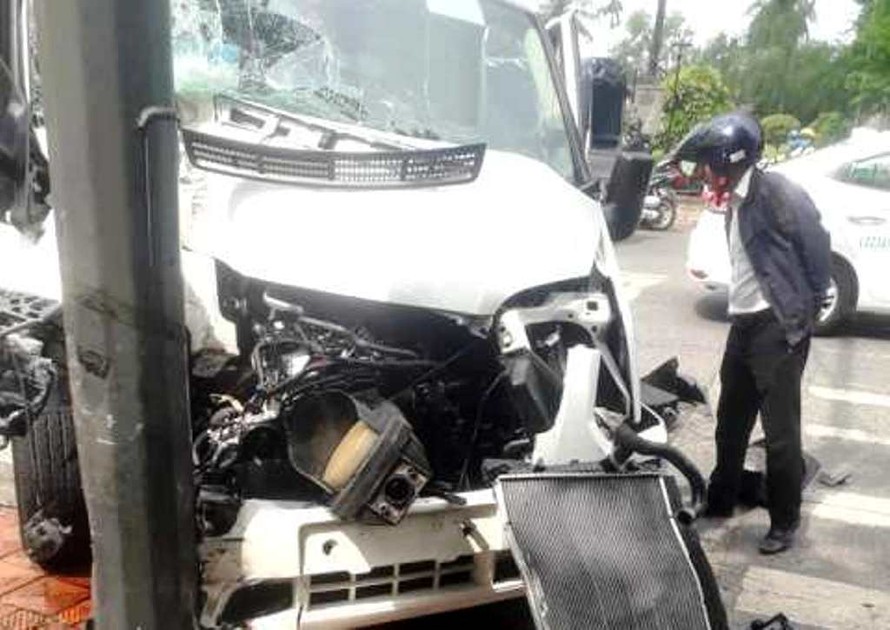 Tại hiện trường vụ tai nạn, xe ô tô du lịch đâm vào trụ đèn tín hiệu bị hư hỏng nặng phần đầu (ảnh A.Phong)
