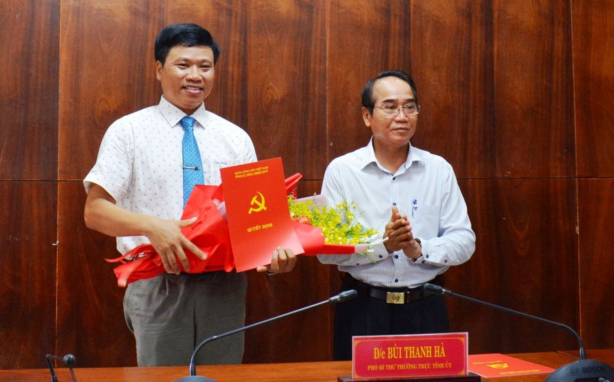 Ông Bùi Thanh Hà, Phó Bí thư Thường trực Tỉnh ủy TT-Huế (bìa phải) trao quyết định và tặng hoa, chúc mừng ông Phan Xuân Toàn. (Ảnh Anh Phong).