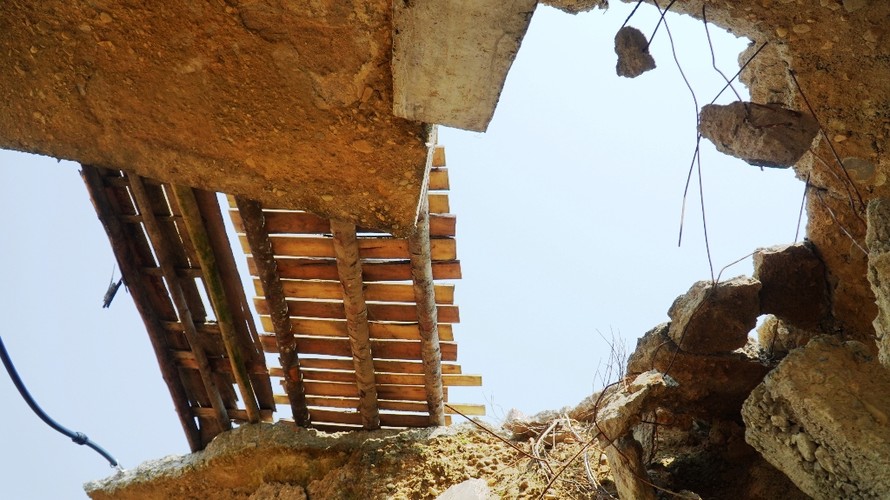 Mố cầu Khe Chai bị vỡ nát, lộ ra các mảng dầm đúc và những kết cấu bê tông có lõi thép nhỏ bé đáng ngờ.