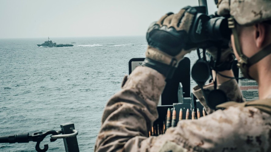 Một lính thủy đánh bộ Mỹ quan sát một tàu Iran đi qua eo biển Hormuz. Ảnh: Reuters 