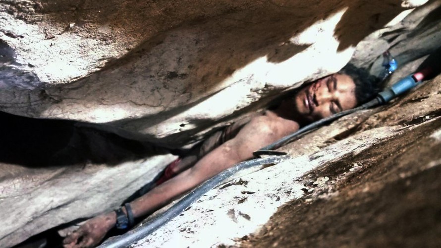 Một người đàn ông Campuchia bị mắc kẹt giữa các tảng đá. Ảnh: AP