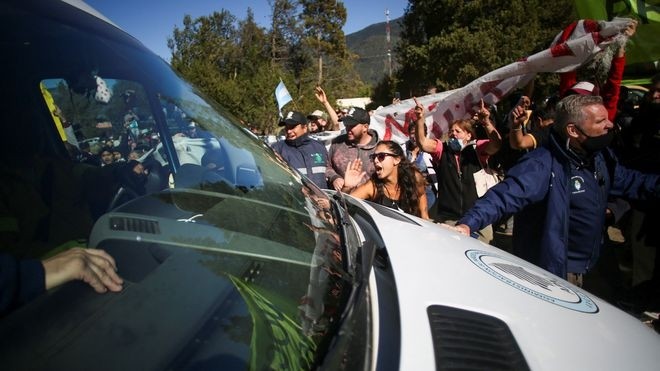 Người biểu tình bao vây chiếc xe chở Tổng thống Alberto Fernandez. Ảnh: Reuters
