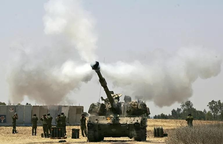 Một chiếc xe tăng của quân đội Israel bắn về phía Dải Gaza. Ảnh: AP