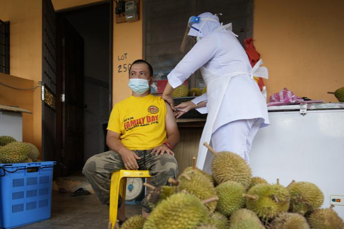 Y tá tiêm vaccine COVID-19 cho một người bán sầu riêng tại bang Selangor, Malaysia. Ảnh: AP