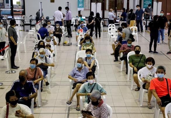 Người dân Singapore xếp hàng tiêm vắc xin COVID-19. Ảnh: Reuters