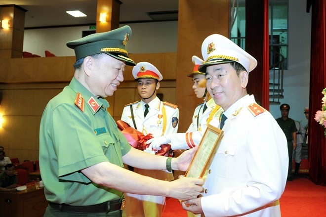 Bộ trưởng Tô Lâm trao Quyết định của Chủ tịch nước thăng cấp bậc hàm từ Thiếu tướng lên Trung tướng cho Thứ trưởng Trần Quốc Tỏ. (ảnh: mps)