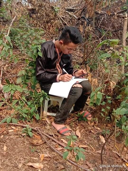Tranh thủ giờ nghỉ làm, cậu học trò dân tộc Mông Sùng A Sì ngồi ở rừng làm bài tập nộp cho đúng thời hạn của cô giáo đưa ra.