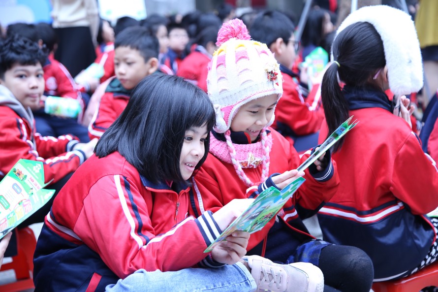 Các em học sinh trường Tiểu học Dịch vọng A dang đọc các thông tin về phân loại rác thải, bảo vệ môi trường