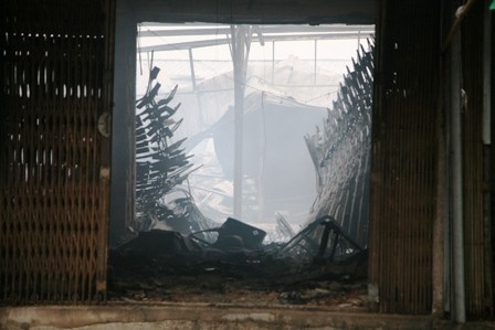 Đằng sau một ki ốt bị cháy là cảnh hoang tàn của chợ Phủ Lý thời điểm này (ảnh chụp lúc 7h sáng). Ảnh: Dân Trí.