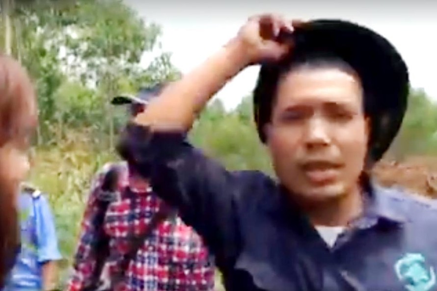 Nhóm người tư xưng là bảo vệ của Cty Phú Hà cầm mũ cối đánh phóng viên. Ảnh cắt từ clip