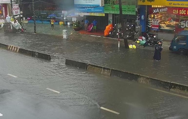 Nước tràn trên mặt đường Nguyễn Hữu Cảnh trong trận mưa nhỏ trưa 3/9.