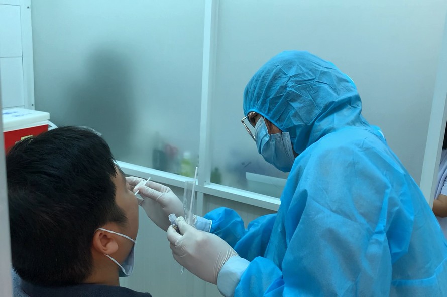 Nhân viên y tế lấy mẫu xét nghiệm cho người về từ Đà Nẵng.