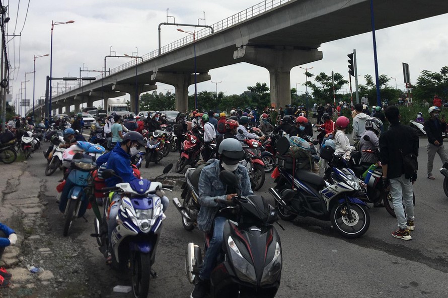 Đến trưa 15/8, hàng trăm người dân đi xe máy về quê vẫn đang dừng đậu trước chốt kiểm soát trên tuyến quốc lộ 1 đoạn qua phường Linh Trung, TP Thủ Đức, TPHCM.