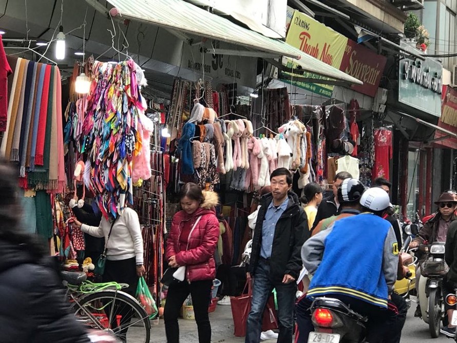 người dân và du khách phải đi bộ dưới lòng đường Phố Đinh Liệt vì viar hè đã bị lấn chiếm kinh doanh quần áo