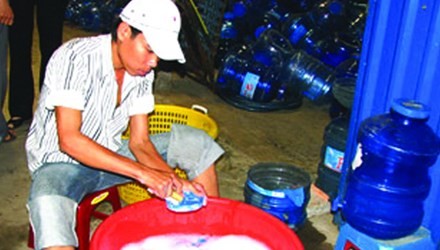 Bình đựng nước được xử lý qua loa bằng nước rửa bát tại một cơ sở sản xuất nước đóng bình tại TPHCM. Ảnh: Lê Nguyễn 