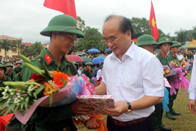 Ông Lý Vinh Quang (bìa phải) tặng hoa, động viên tân binh lên đường nhập ngũ. Ảnh: TL.