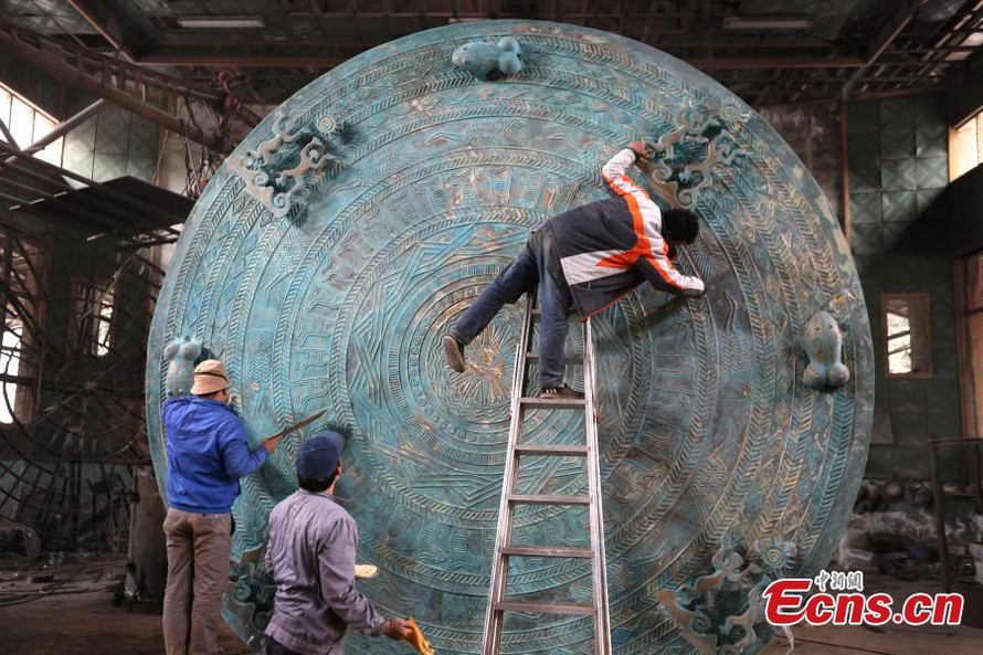 Các công nhân hoàn thiện phần họa tiết trên mặt chiếc trống đồng được cho là lớn nhất thế giới.