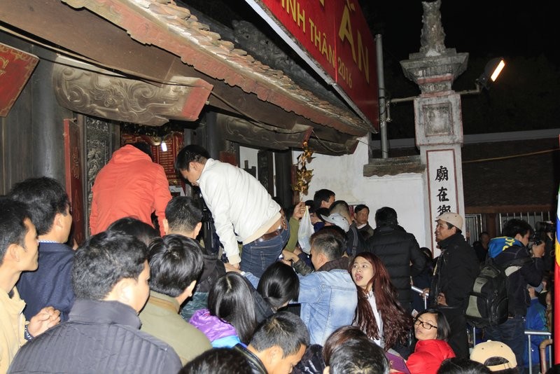 Cảnh trèo rào vào cướp lộc ở đền Thiên Trường. Ảnh: Trường Phong