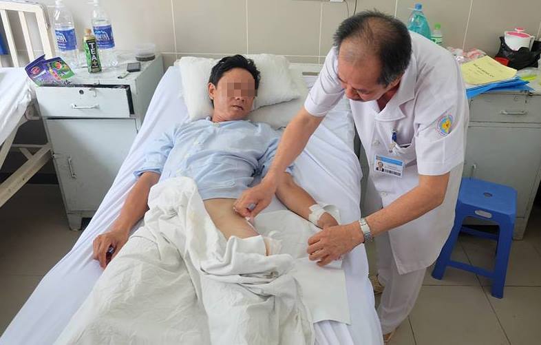 Bác sĩ Lộc đang thăm khám cho bệnh nhân sau ca mổ. Ảnh: Quốc Ngọc.