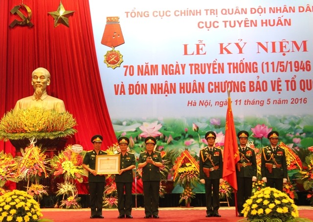 Thừa uỷ quyền Chủ tịch nước, Đại tướng Ngô Xuân Lịch trao Bằng chứng nhận và gắn Huân chương Bảo vệ Tổ quốc hạng Nhất lên Quân kỳ Quyết thắng của Cục Tuyên huấn.