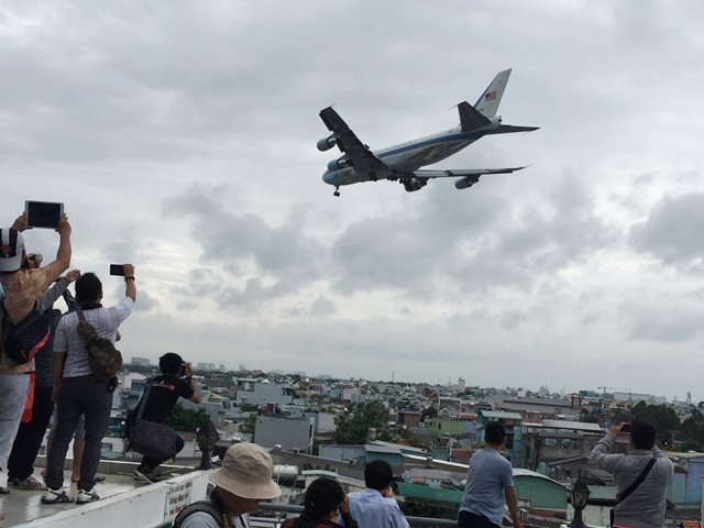 Nhiều người dân leo lên nóc nhà, sân thượng chờ đợi khoảng khắc landing của Air Force One. Ảnh: Quốc Ngọc.