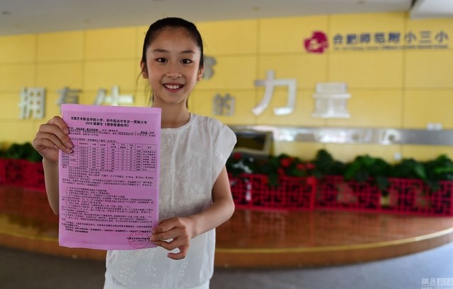Học sinh tiểu học Huang Sihan cầm trên tay giấy tuyển thẳng của trường Đại học nghệ thuật An Huy.