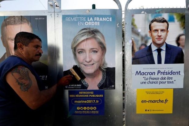 Poster của hai ứng viên dán trên đường phố Pháp. Ảnh: Reuters