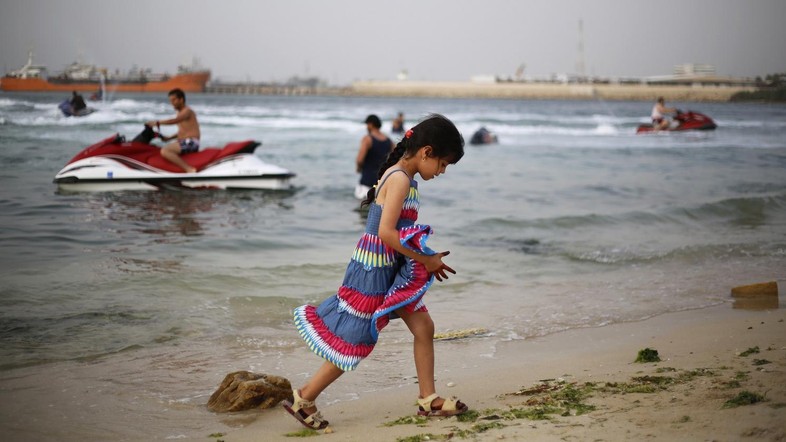 Một bé gái người Libya dạo chơi trên bờ biển tại thủ đô Tripoli. Ảnh: Reuters