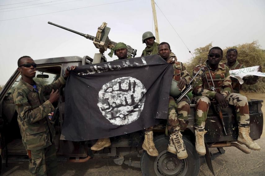 Các binh sĩ của chính phủ Nigeria cầm lá cờ thu giữ được từ phiến quân Boko Haram. Ảnh: Reuters
