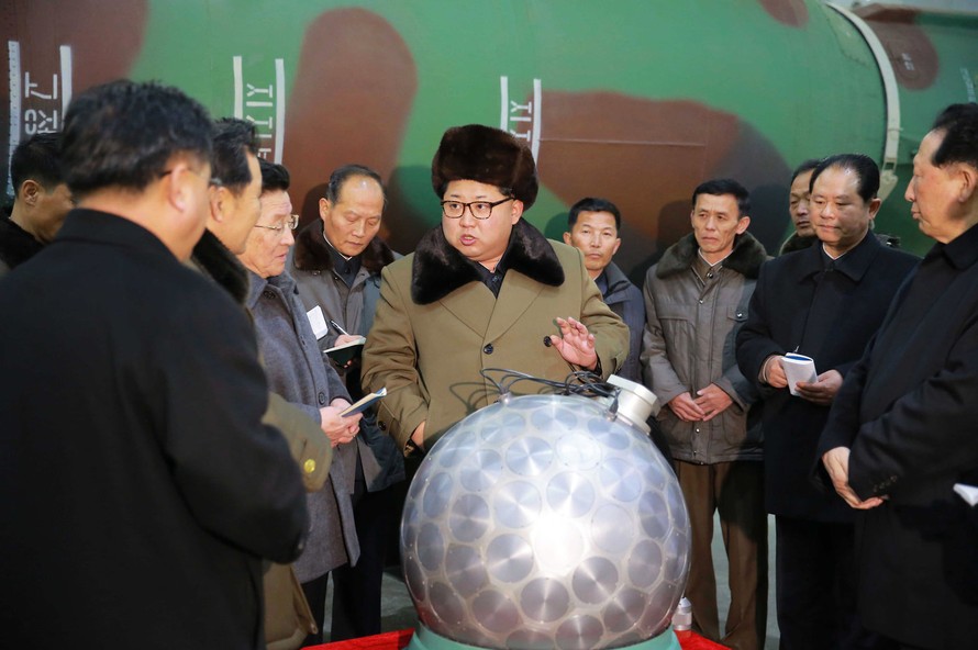 Chủ tịch Triều Tiên Kim Jong-un (giữa) nói chuyện về các nhà khoa học và chuyên viên kĩ thuật về mô hình đầu đạn hạt nhân, được Bình Nhưỡng gọi là "quả cầu disco". Ảnh: KCNA