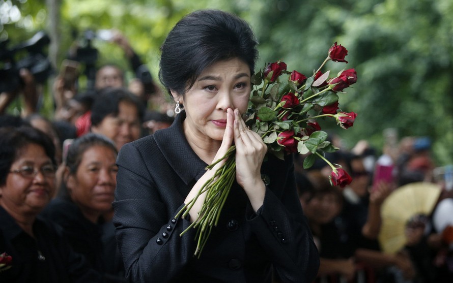 Cựu Thủ tướng Yingluck xúc động khi được nhận hoa từ người ủng hộ trong phiên tòa trước đó. Ảnh: AP